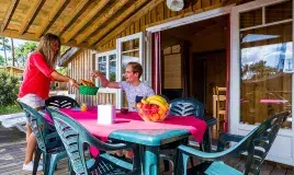 A couple's moment on the terrace of one of the accommodation at Les Embruns campsite